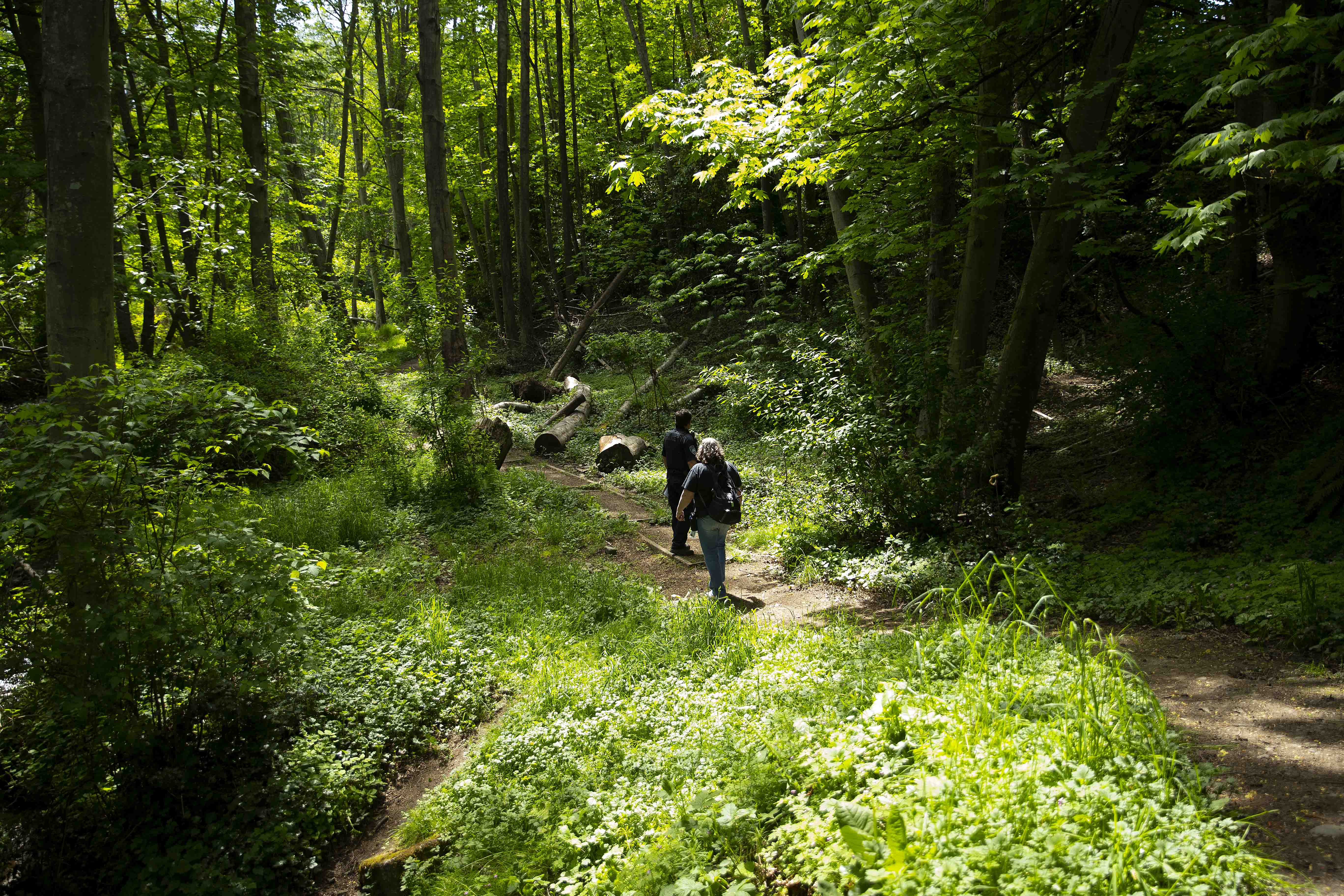 Code enforcement officer with the Port Angeles Police Department, Derek Miller, walks through Peabody Creek while doing co-response with Pam Paine, an outreach coordinator with the Olympic Peninsula Community Clinic and Rediscovery Program on Tuesday, May 16, 2023, in Port Angeles. KUOW Photo/Megan Farmer.